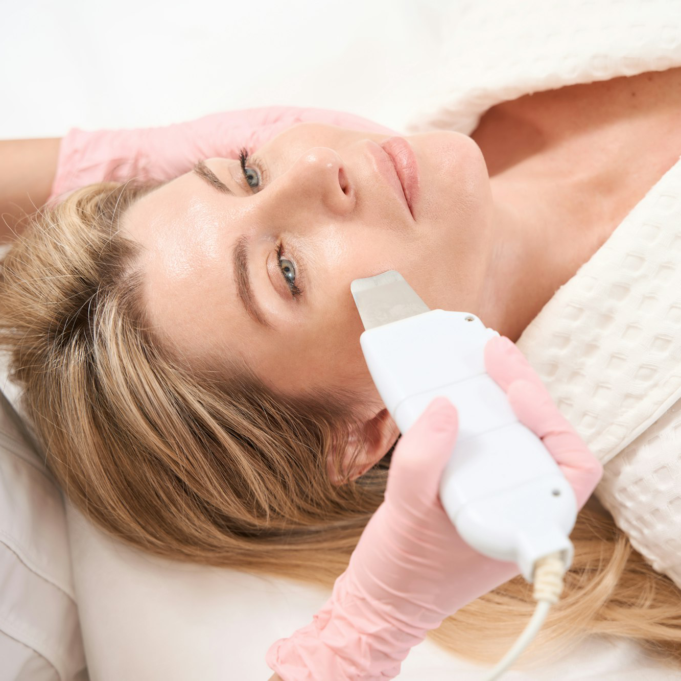 Woman on the procedure of ultrasonic facial cleansing